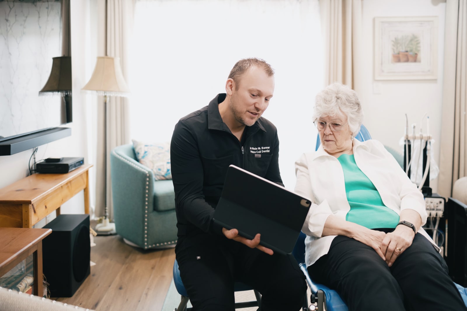 Dentist consulting with senior patient in comfortable home environment
