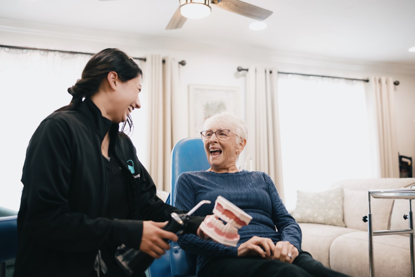 Dental professional explaining treatment to a senior patient in a home setting