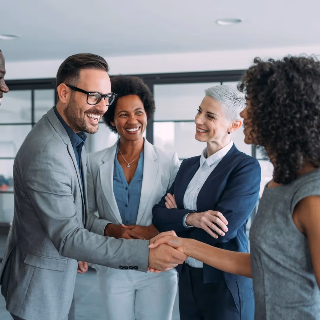 Mix of business professionals shaking hands.