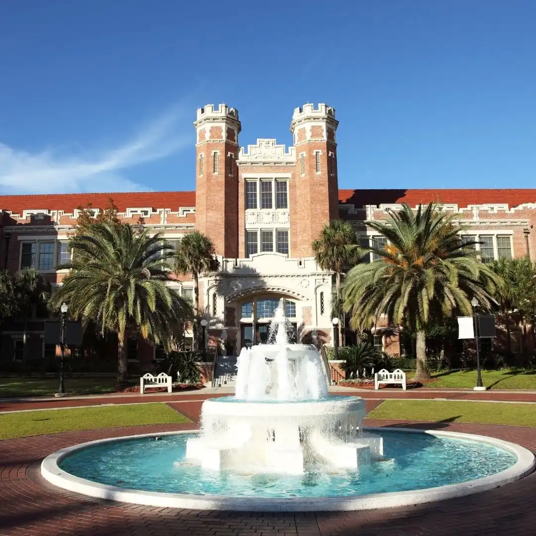 Historic Florida State University Westcott Building with brick towers, fountain, and palm trees on campus