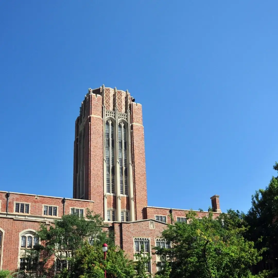 University of Denver tower with Gothic Revival brick architecture against clear blue sky