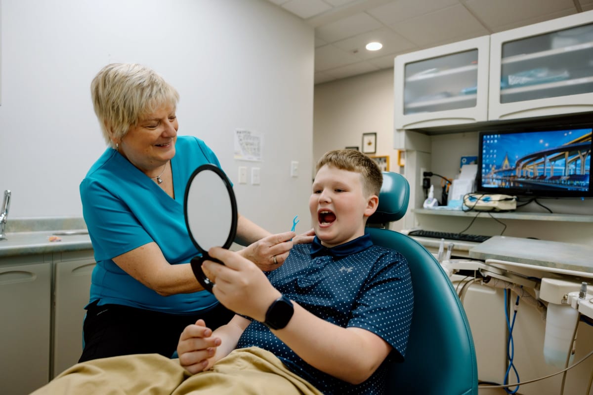 Pediatric dentist applying dental sealants to child's back teeth in Frederick, Maryland office