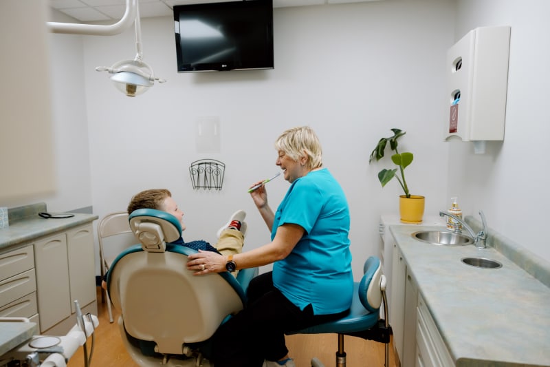 Pediatric dentist applying dental sealant to child's tooth in Frederick, Maryland office