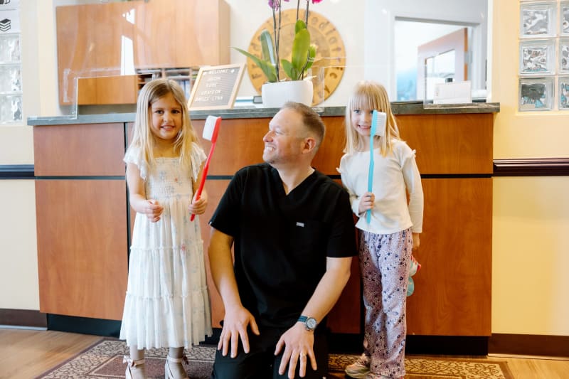 Pediatric dentist examining young child's teeth during routine dental checkup for oral health care