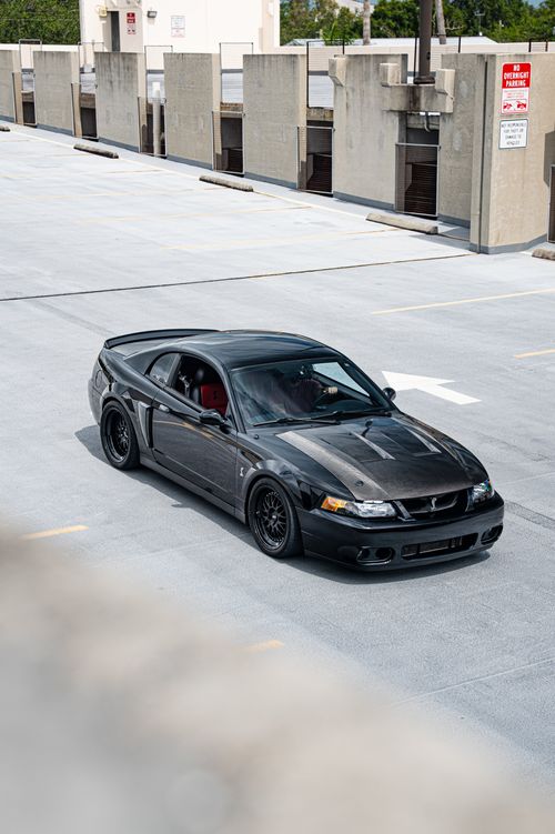 Black Ford Mustang SVT Cobra parked on concrete parking structure