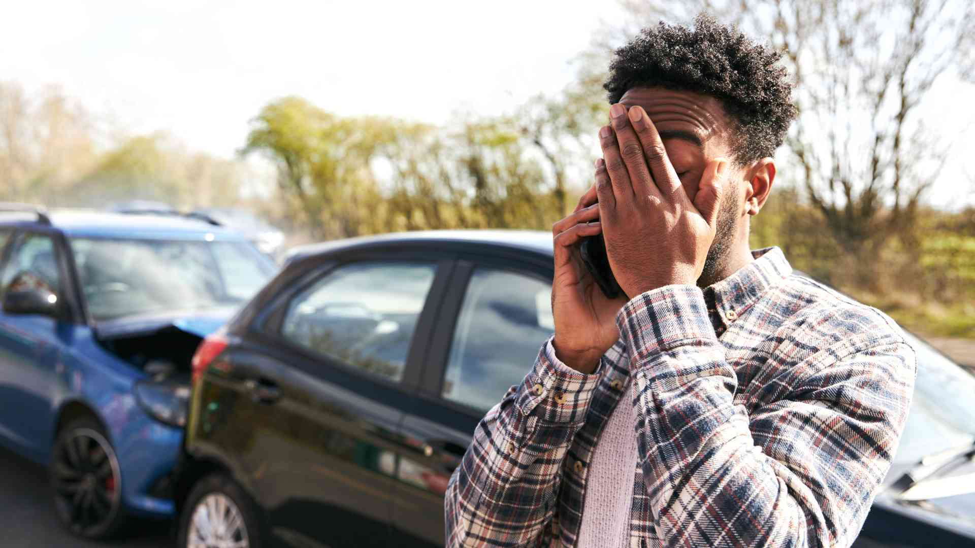 Man calling for the courtesy car service after getting involved in the car collision