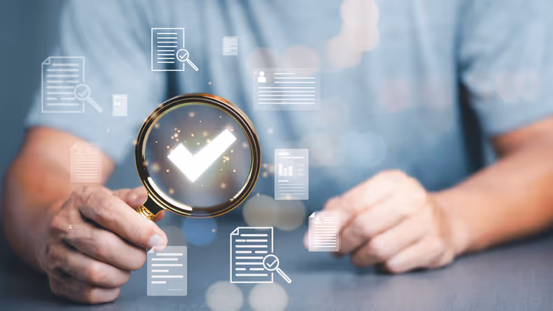 stock photo hand holding magnifying glass over illuminated checkmark