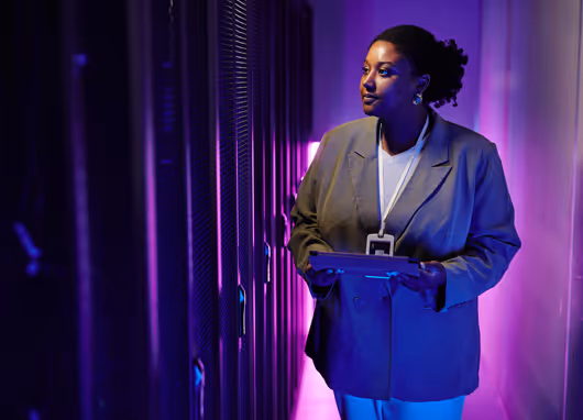 stock photo woman looking at servers purple background
