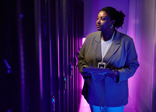 stock photo woman looking at servers purple background