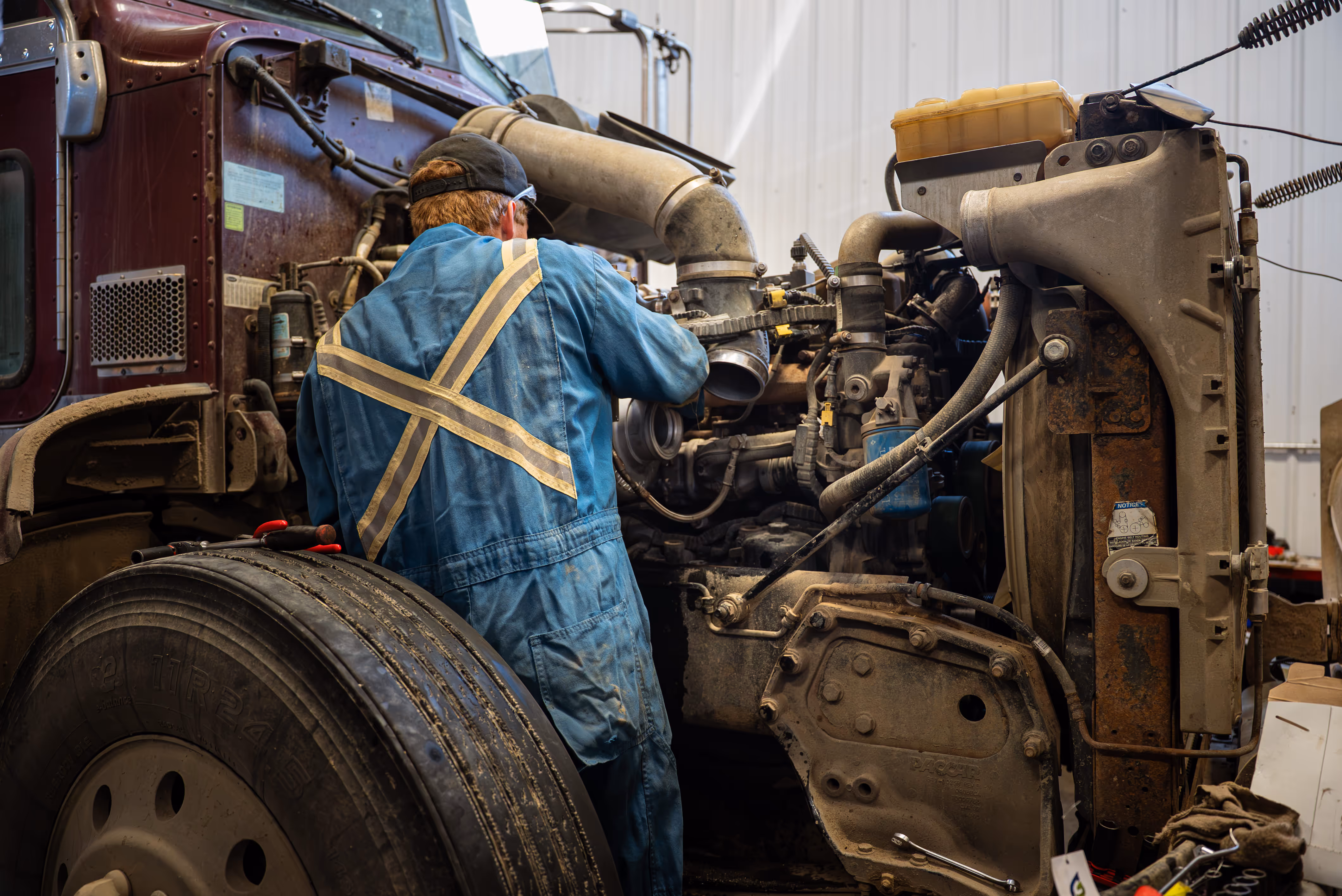 Diesel mechanic performing truck preventive maintenance in Weyburn, SK