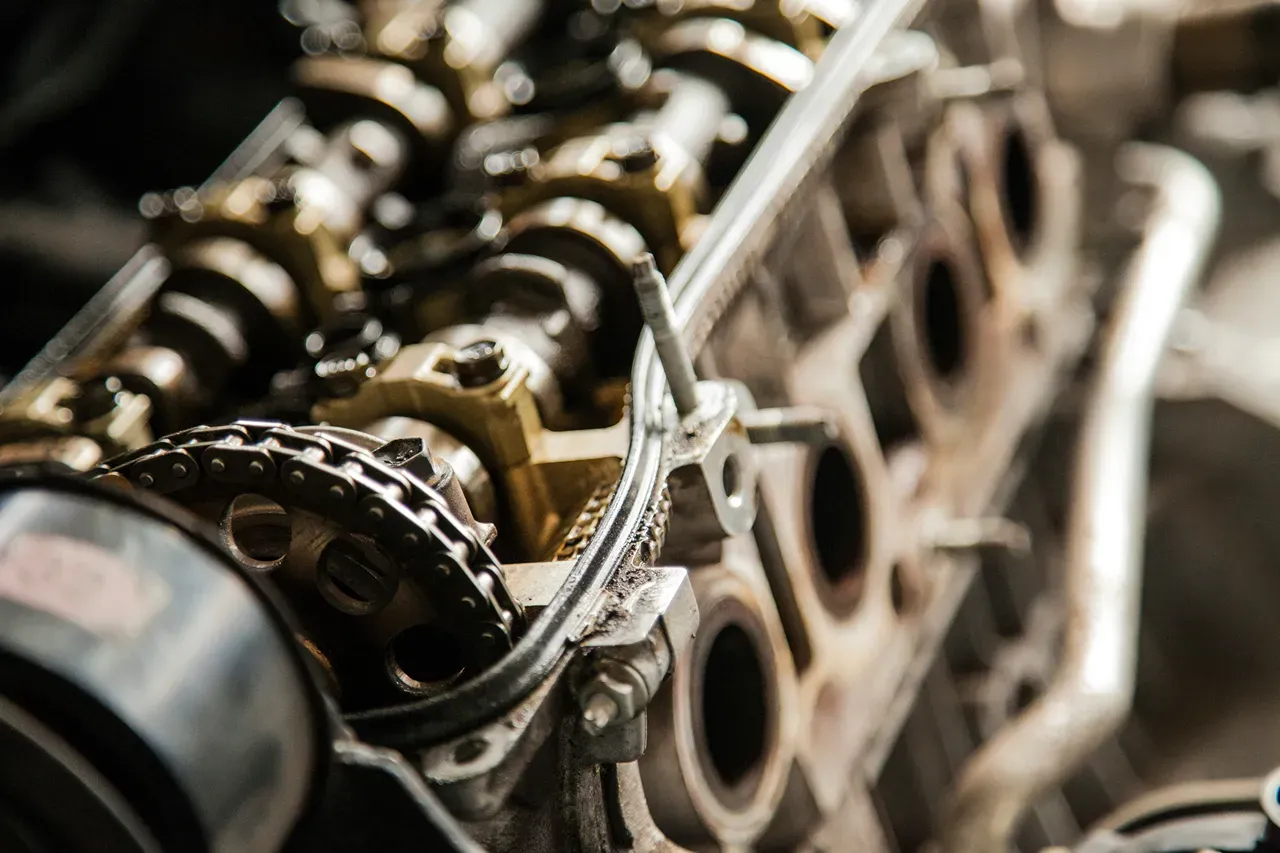 Engine repair service for heavy-duty trucks, showing exposed timing chain, camshaft, and cylinder head components during service.