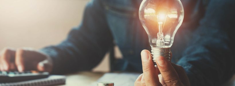 Business,Accounting,With,Saving,Money,With,Hand,Holding,Lightbulb,Concept