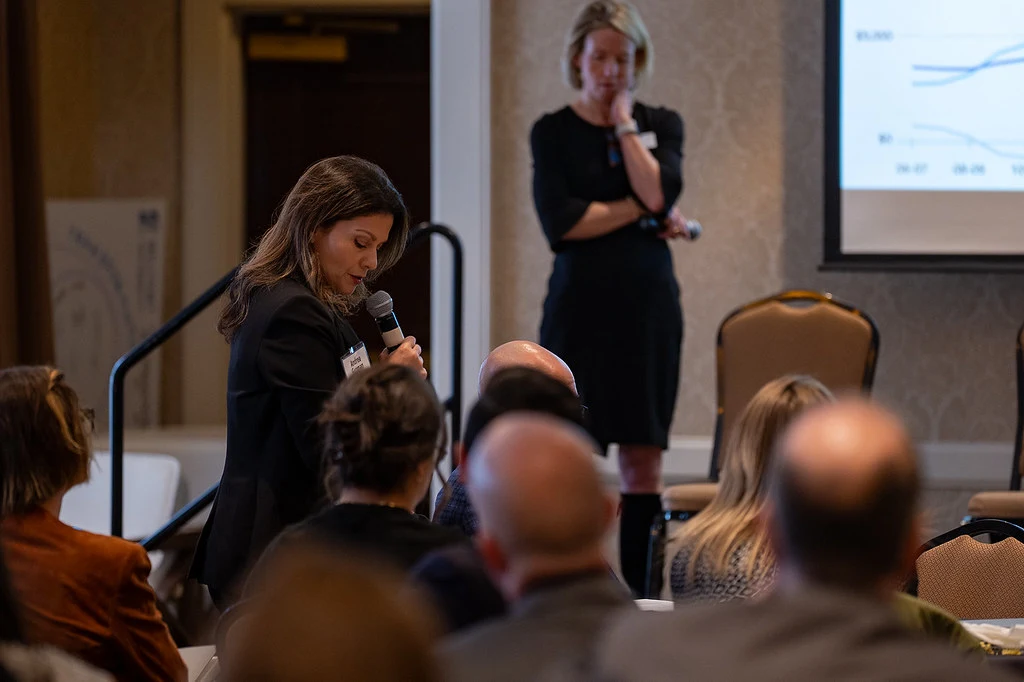An audience member standing up to ask a question at the HEMAC annual convening.