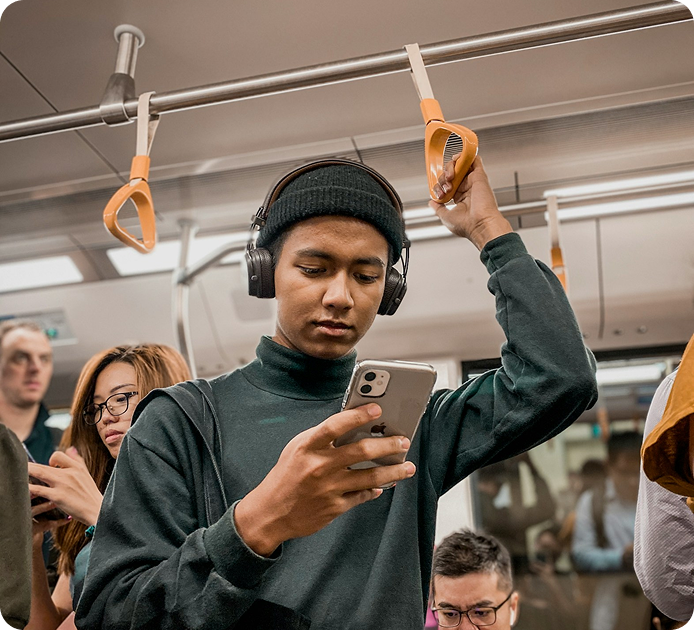Chico en transporte público revisando su celular