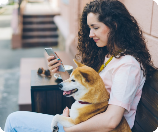 Una mujer con su mascota revisando su celular