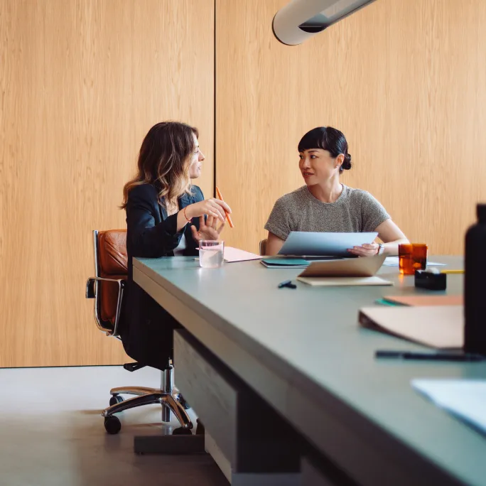Two business people working together at a large table