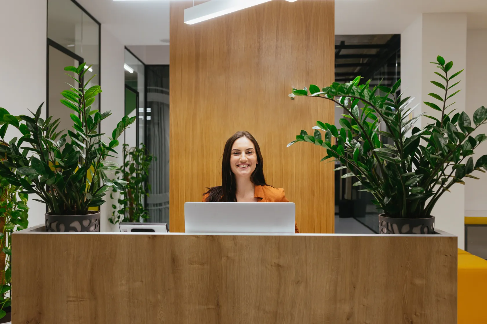 A cheerful receptionist sitting at a desk