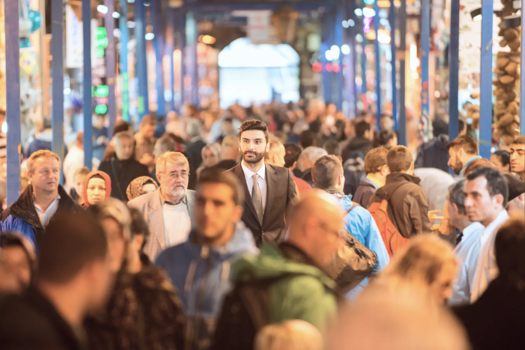 A tall man standing out in a crowded market