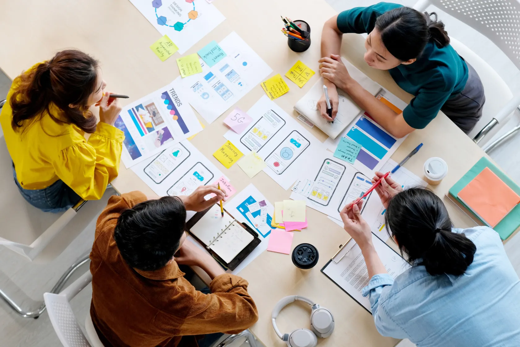 A birds eye view of a team sitting around a table with documents spread out