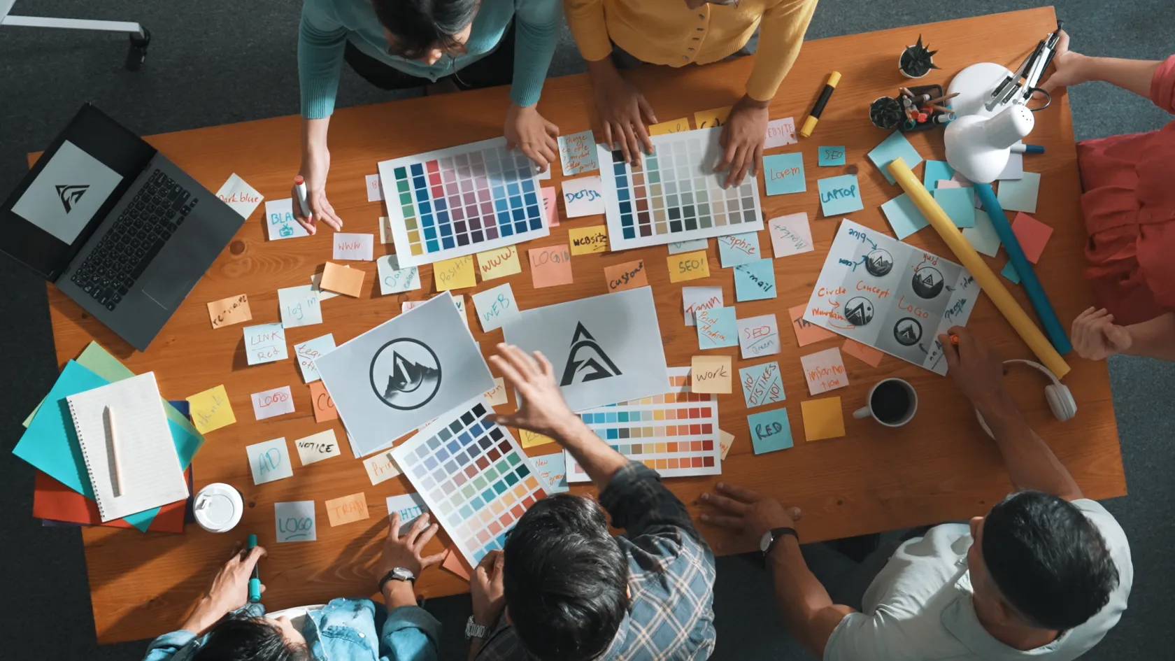 Birds eye view of a team around a table reviewing design documents