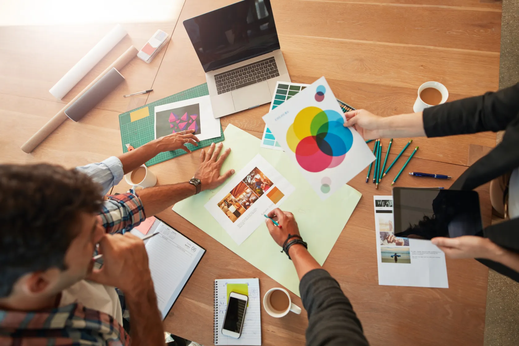 A team reviewing design documents spread out on a table