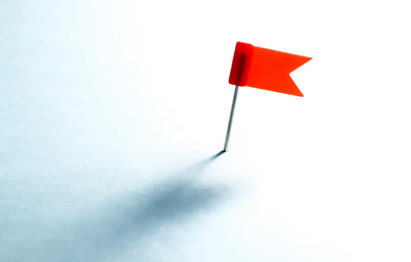 A small red flag stick into a piece of paper