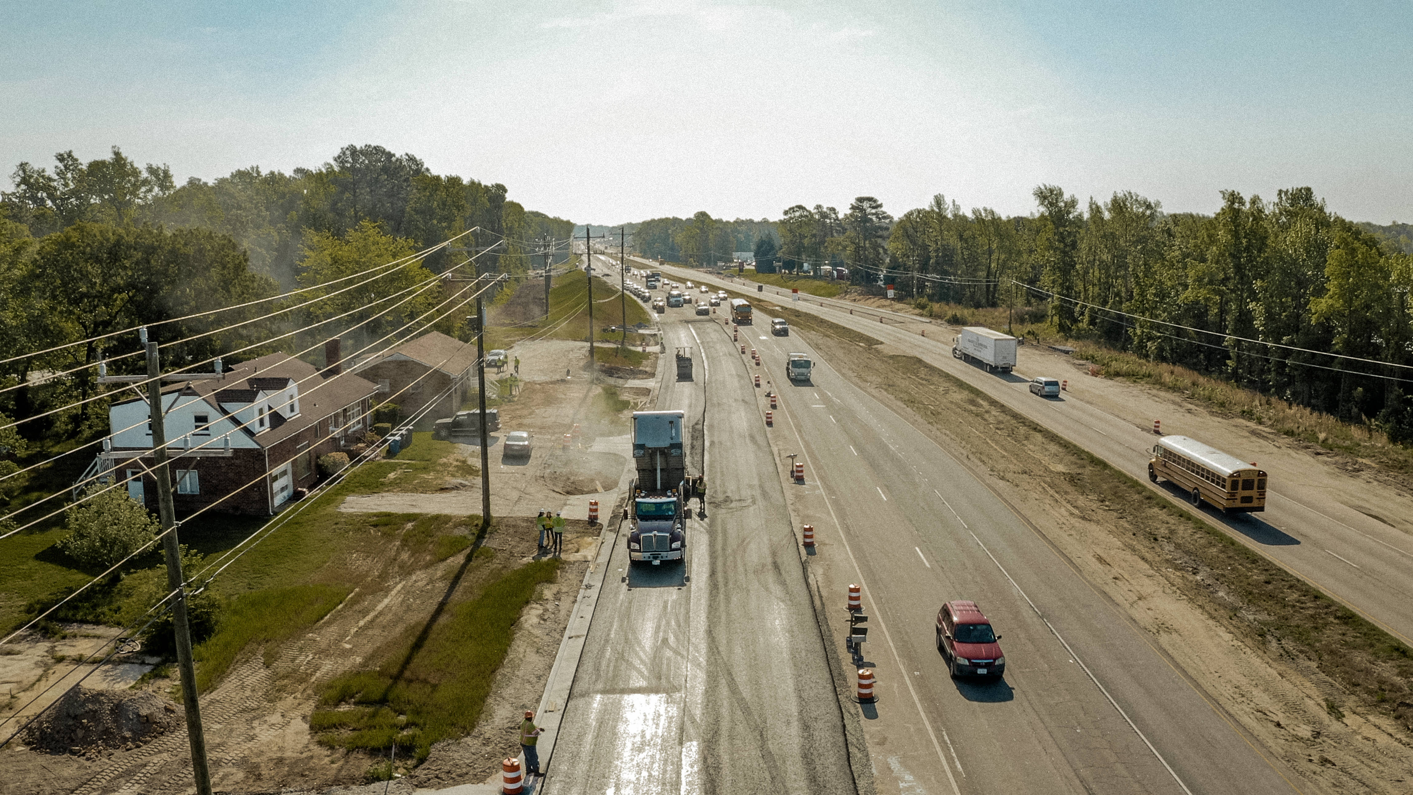 Shirley Gap 64: Paving operation and dump trucks in a coned-off lane.