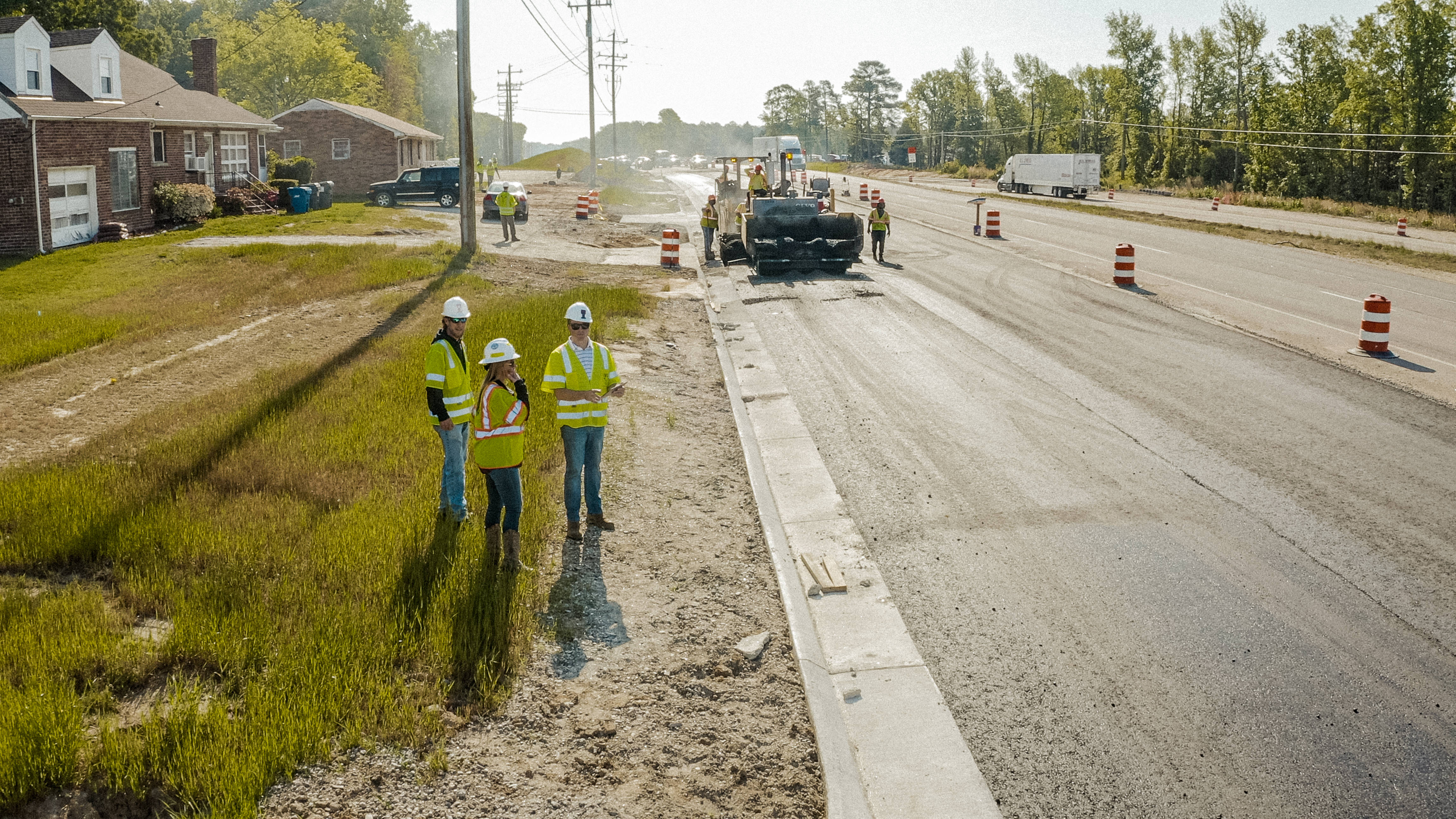 Shirley Gap 64: Road crew standing beside active paving equipment.