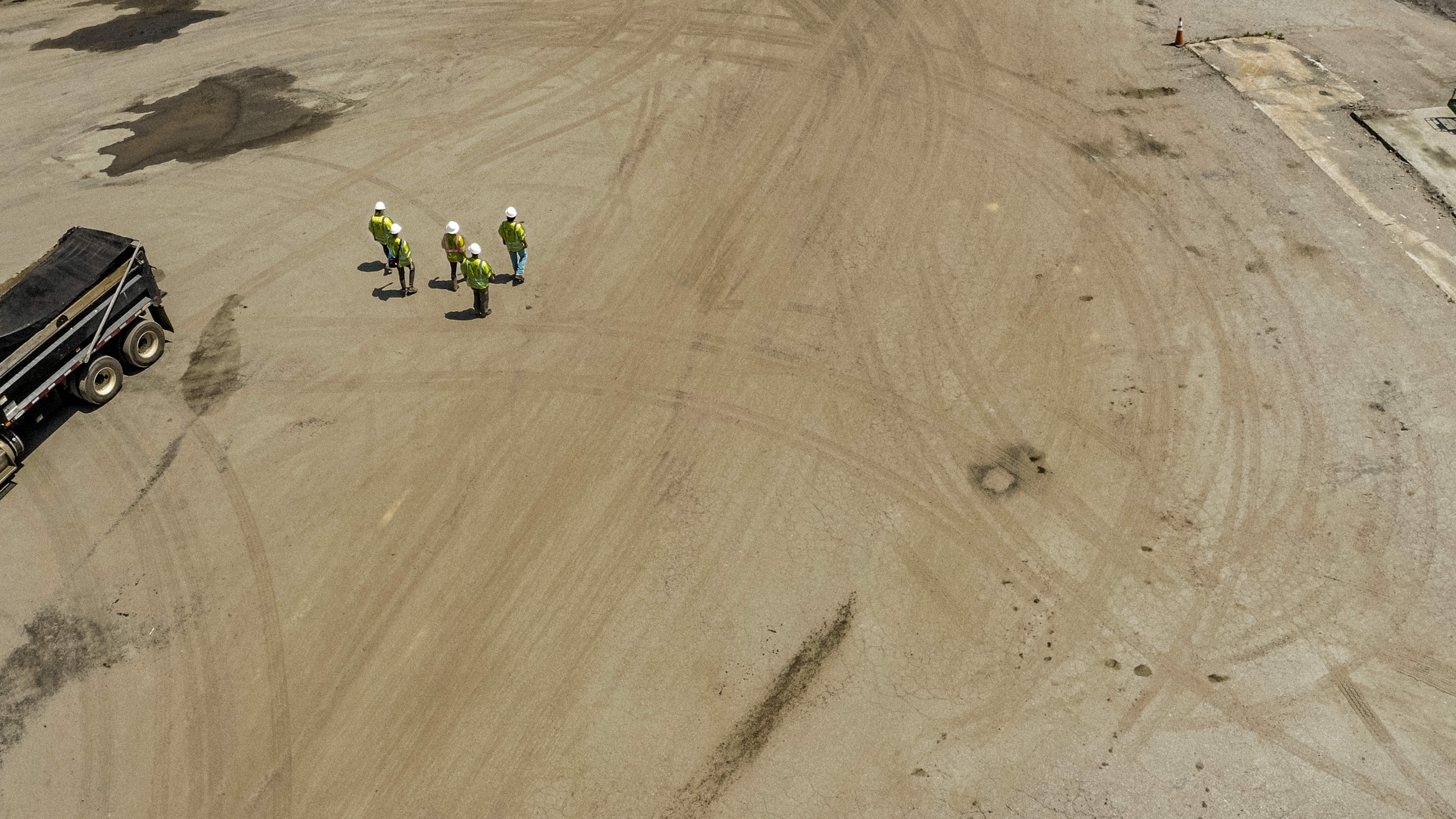 Shirley Gap 64: Three workers on a haul road beside aggregate stockpiles.