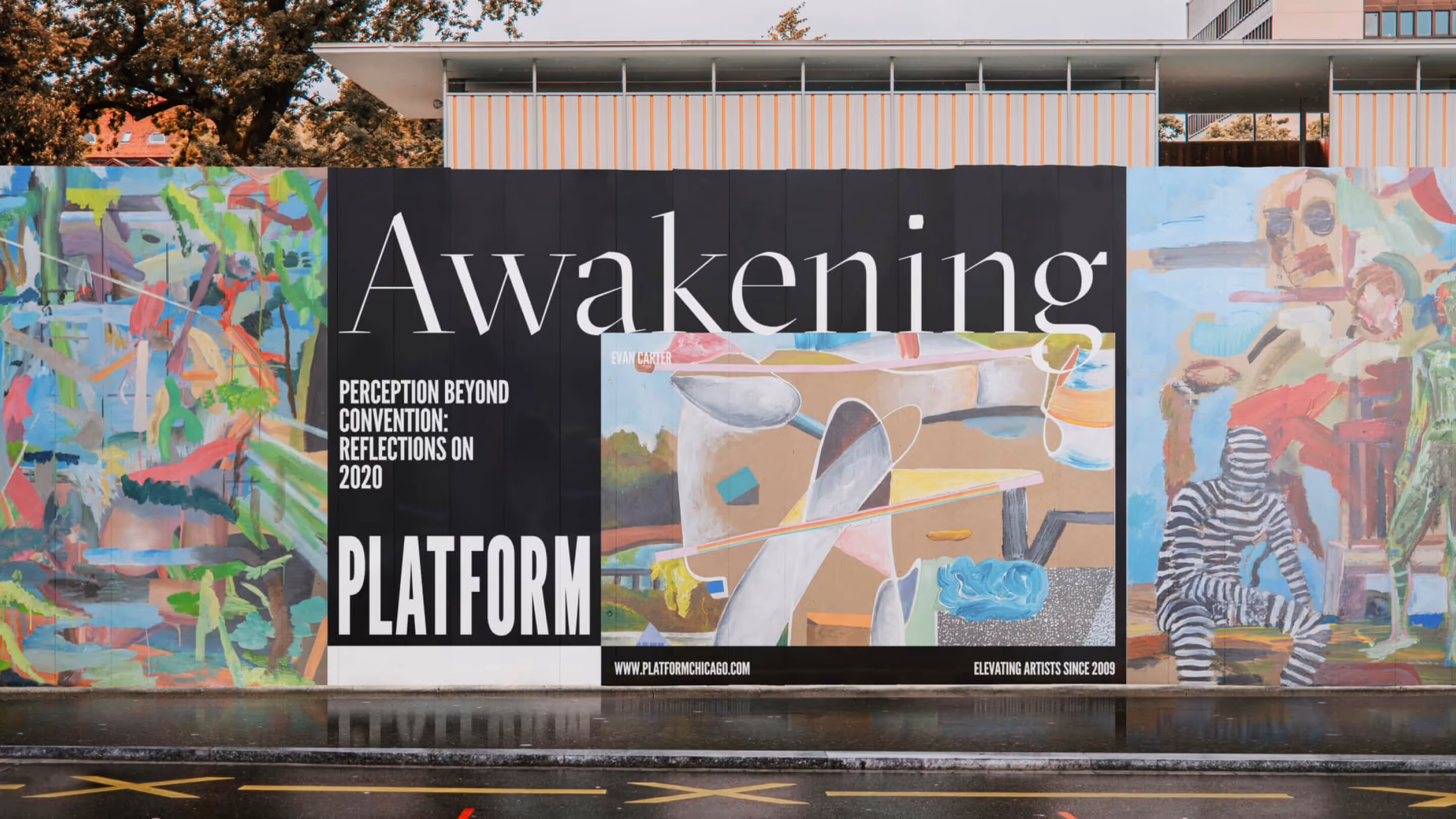 Platform Studios "Awakening" exhibition poster displayed in storefront window with colorful artistic imagery and bold typography