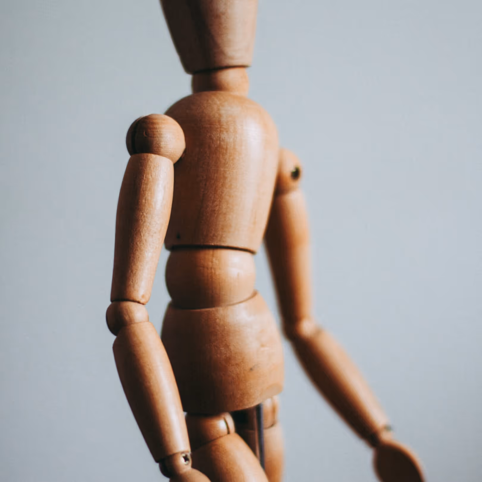 Wooden artist’s mannequin figure photographed in soft light, representing creativity and craftsmanship.