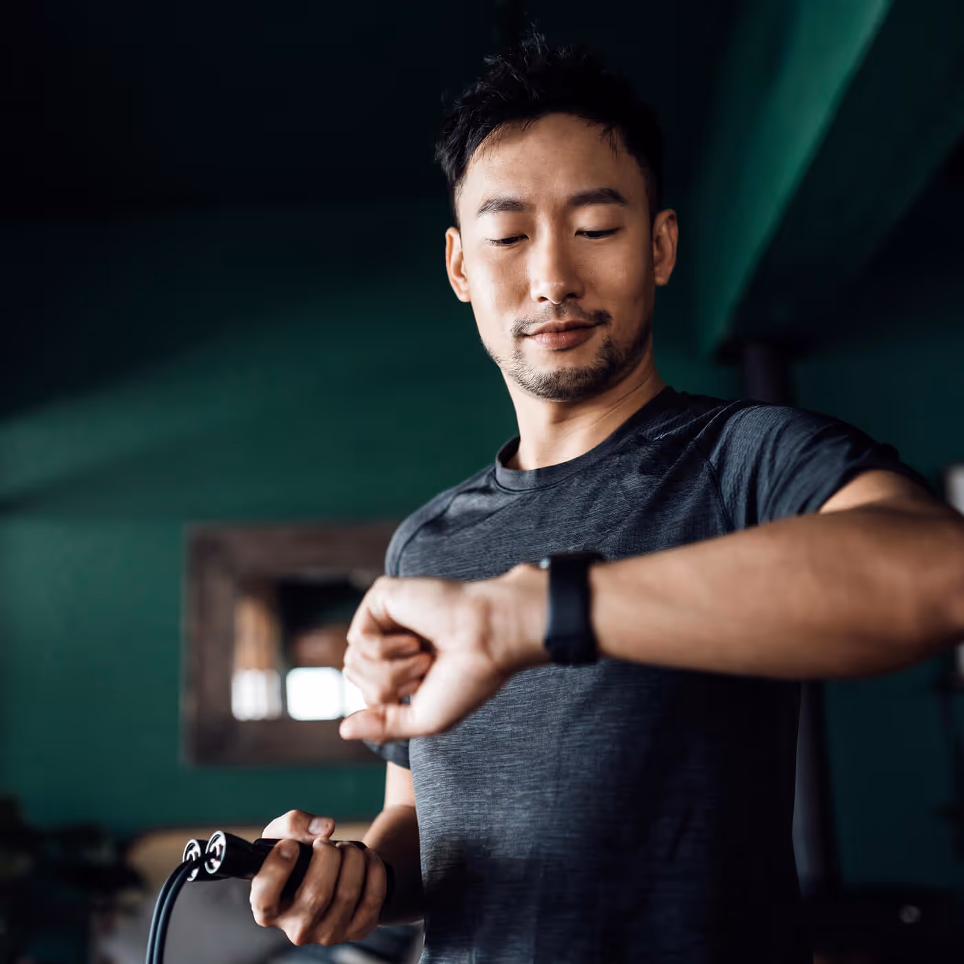 Man in gray athletic wear checking fitness data on smartwatch
