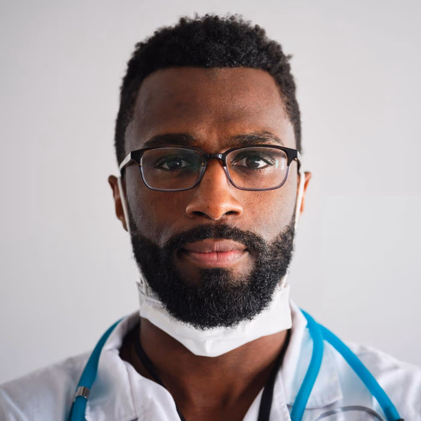 Black male healthcare provider wearing surgical mask and blue stethoscope