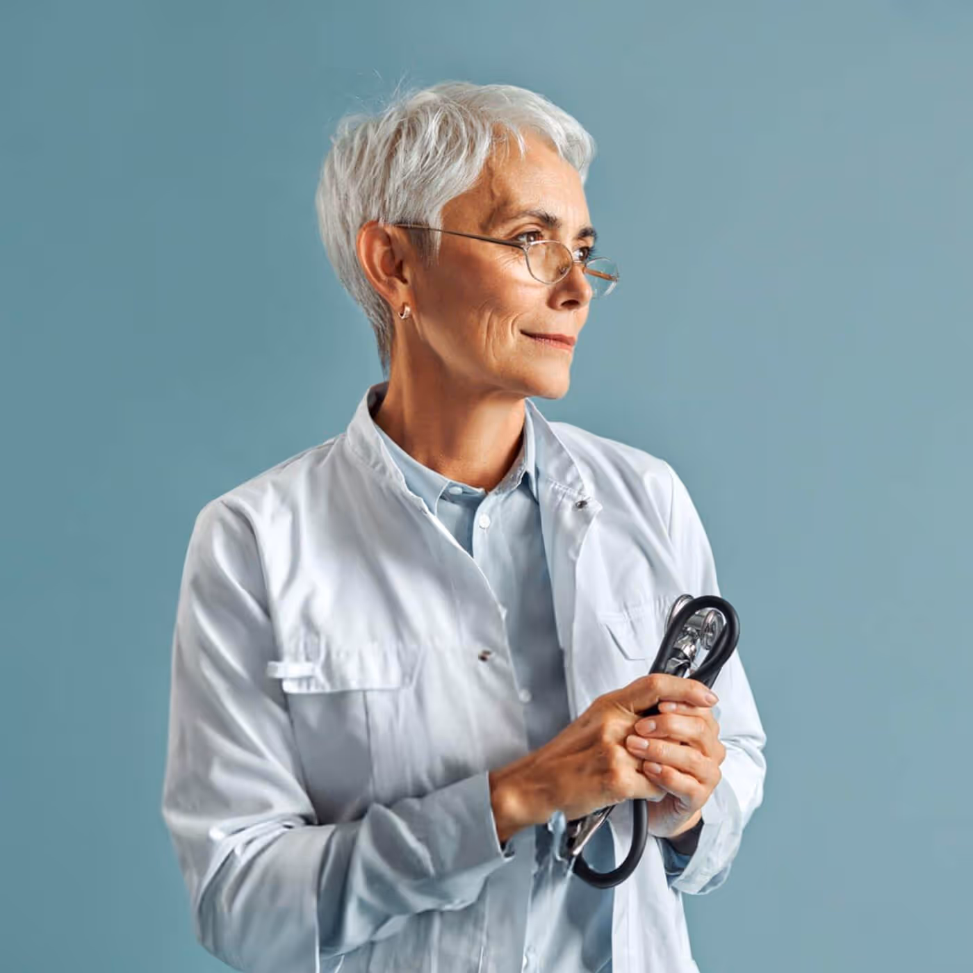 Senior female healthcare professional in white coat holding medical device