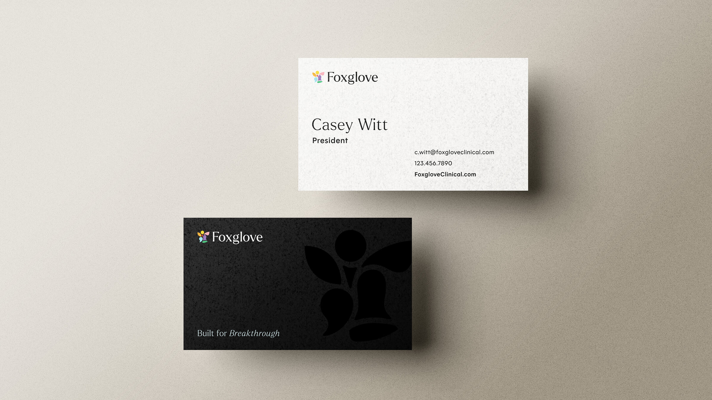 Two Foxglove business cards, one white with contact details for Casey Witt, President, and one black with the Foxglove logo and slogan 'Built for Breakthrough'.