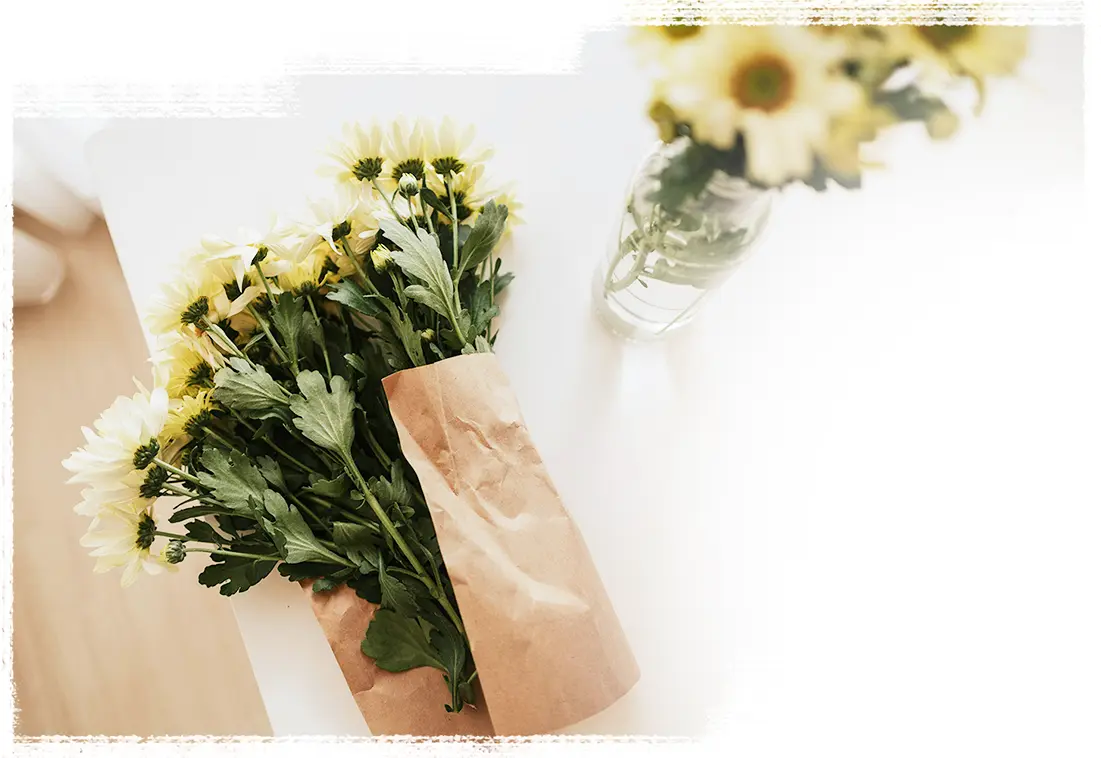 A top view of fresh yellow flowers on a white table.
