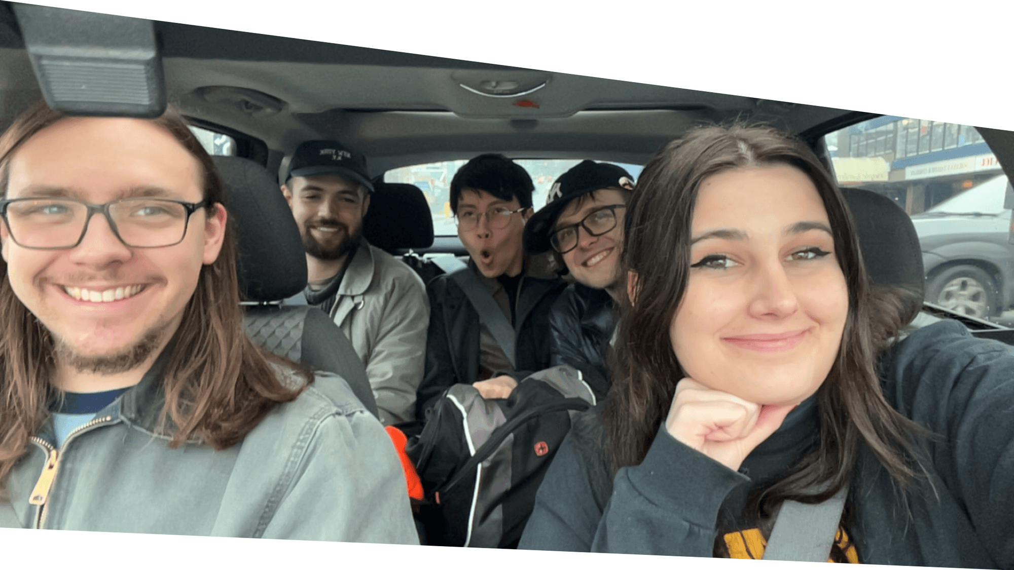 Selfie of CanAssist Mechanical Design Specialist in the passenger seat of a car with co-op students in the passenger seats. Fun being had!