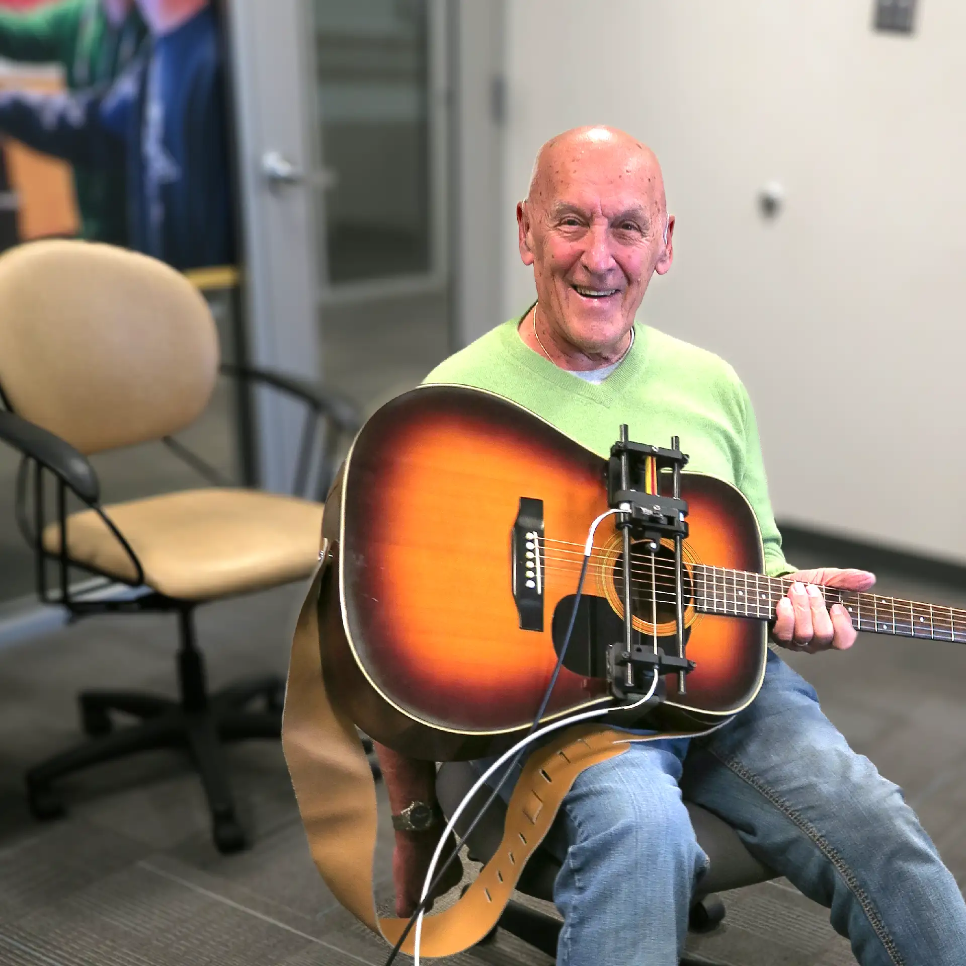 Guitar player using CanAssist's pedal assisted guitar strummer