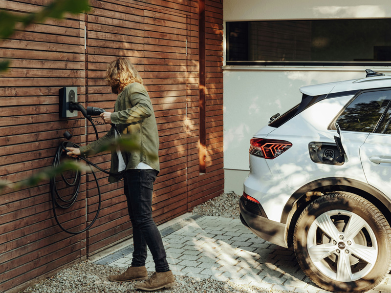 Person plugging in an EV at home