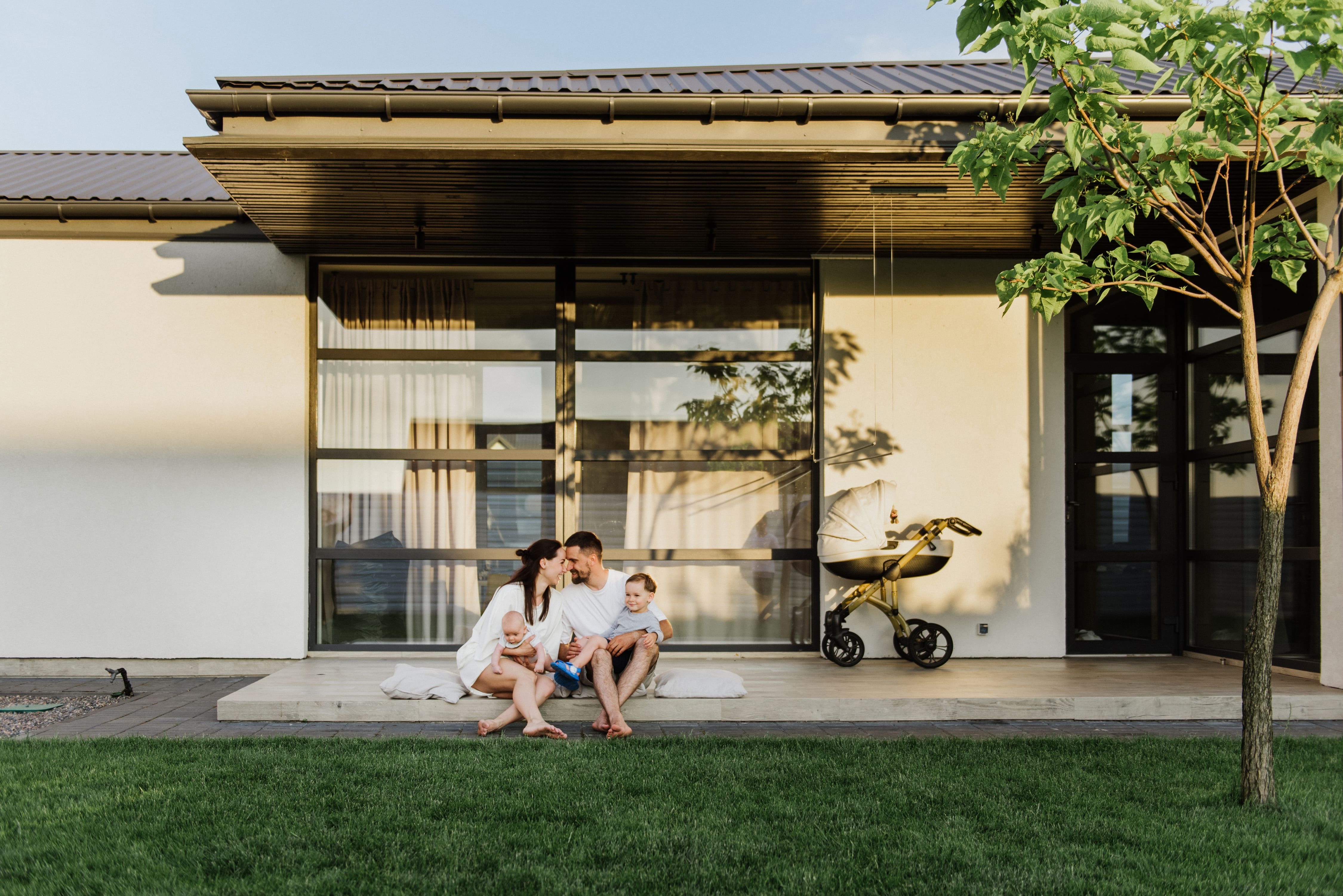 Happy couple sitting in front of new first home