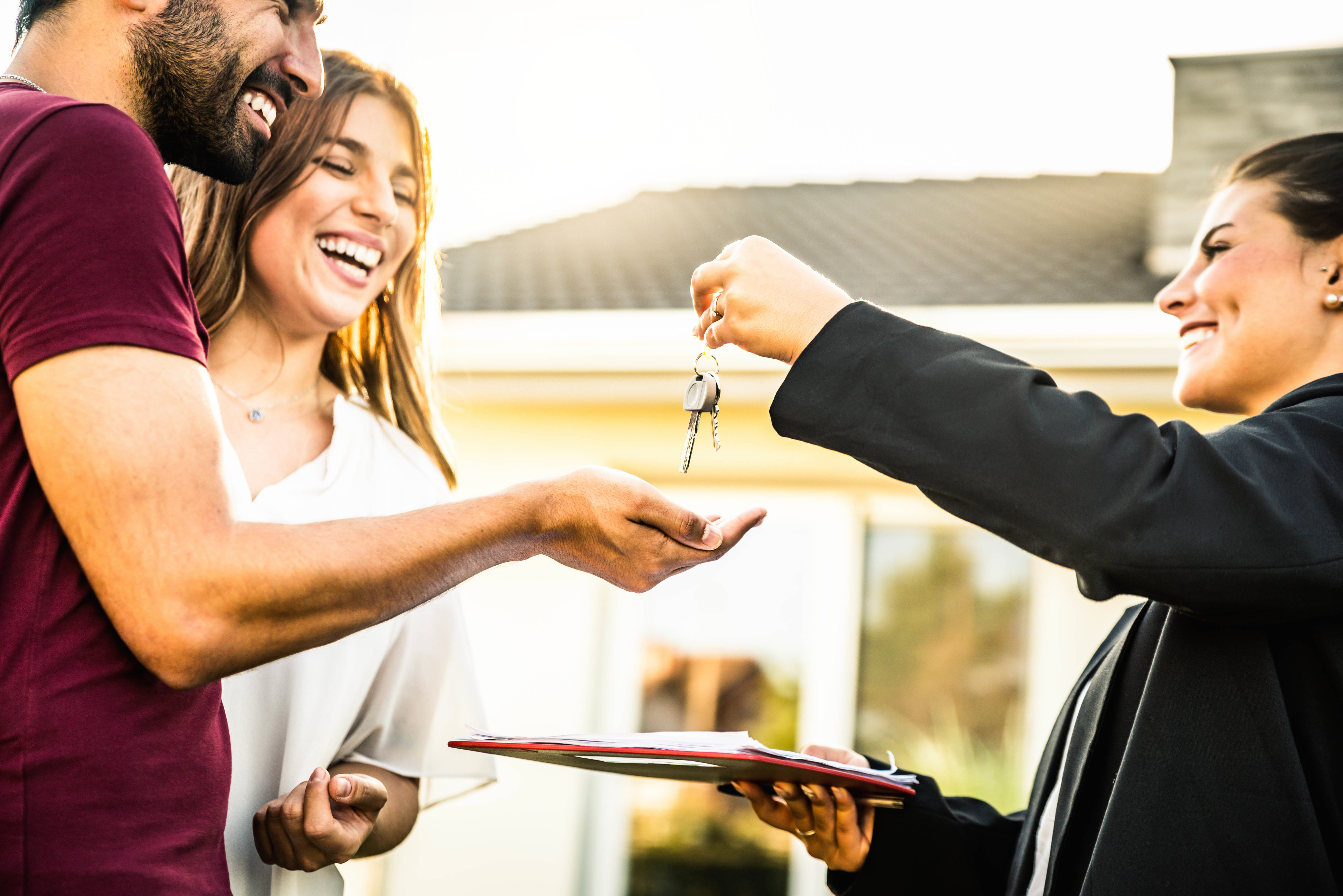 Real estate agent handing keys over to a happy couple