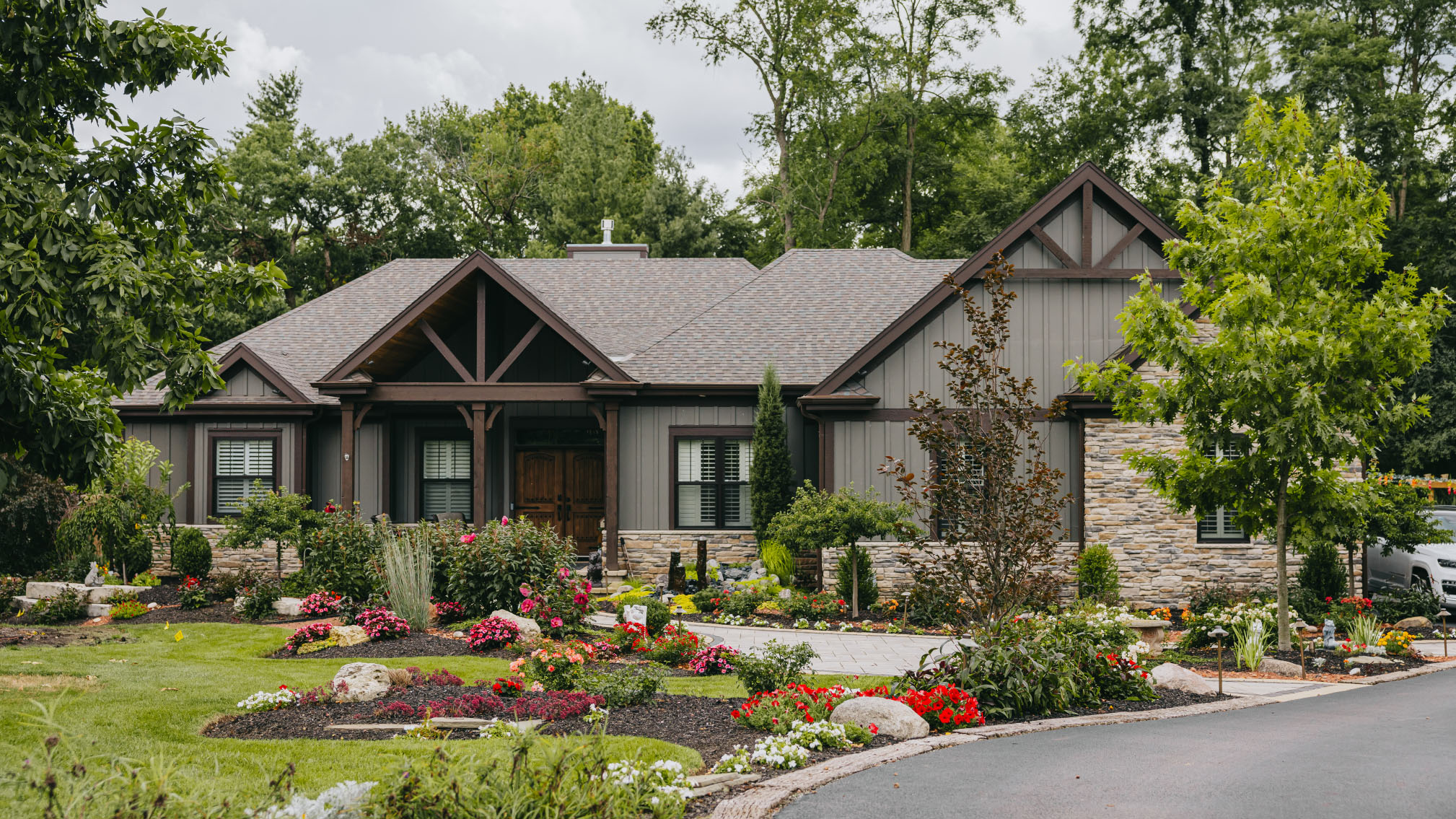 Beautifully landscaped front yard with colorful garden beds and stone walkway at a suburban Chicago home.