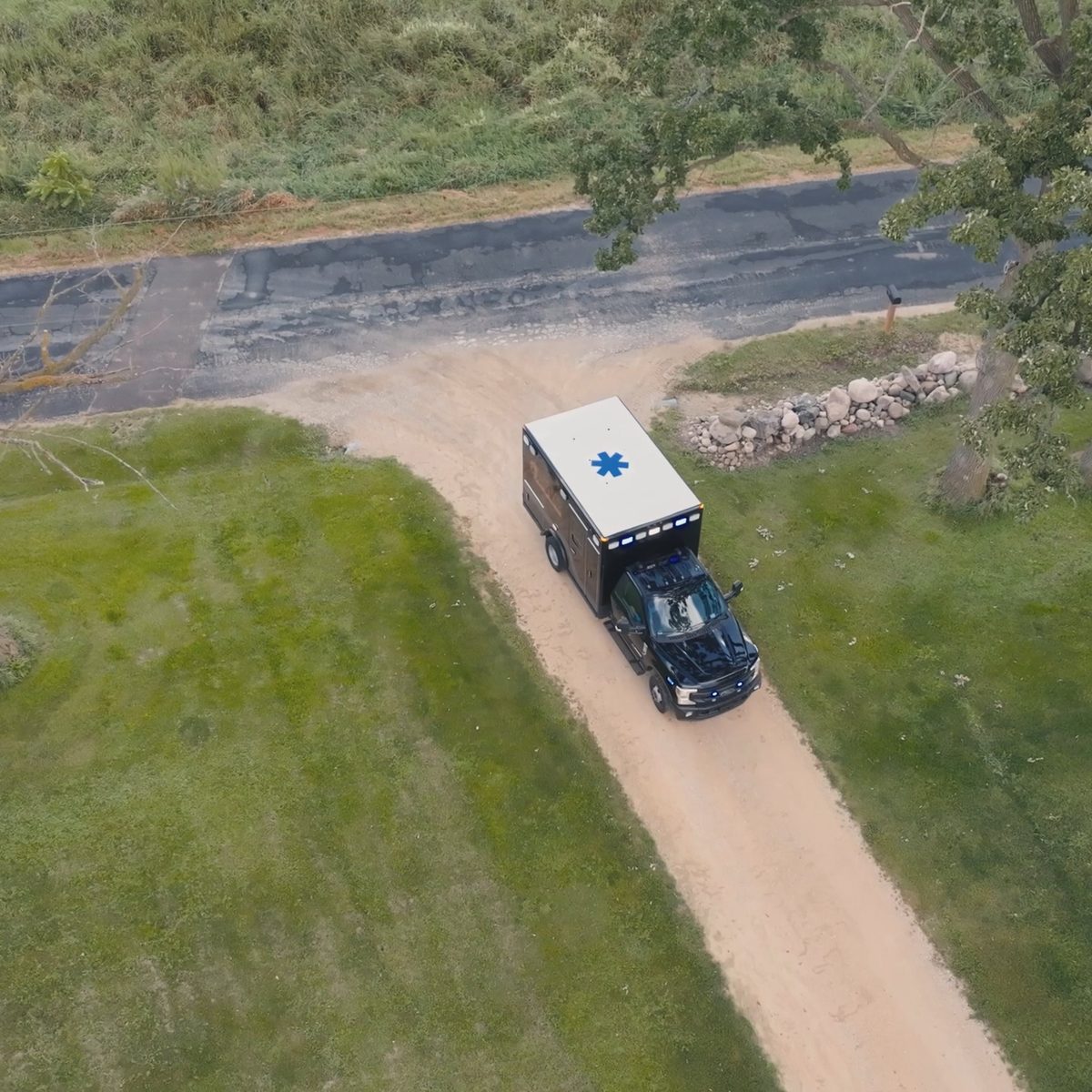 Overhead drone shot of an ambulance driving down a gravel lane, filmed by Identity Start for Northwest Rescue