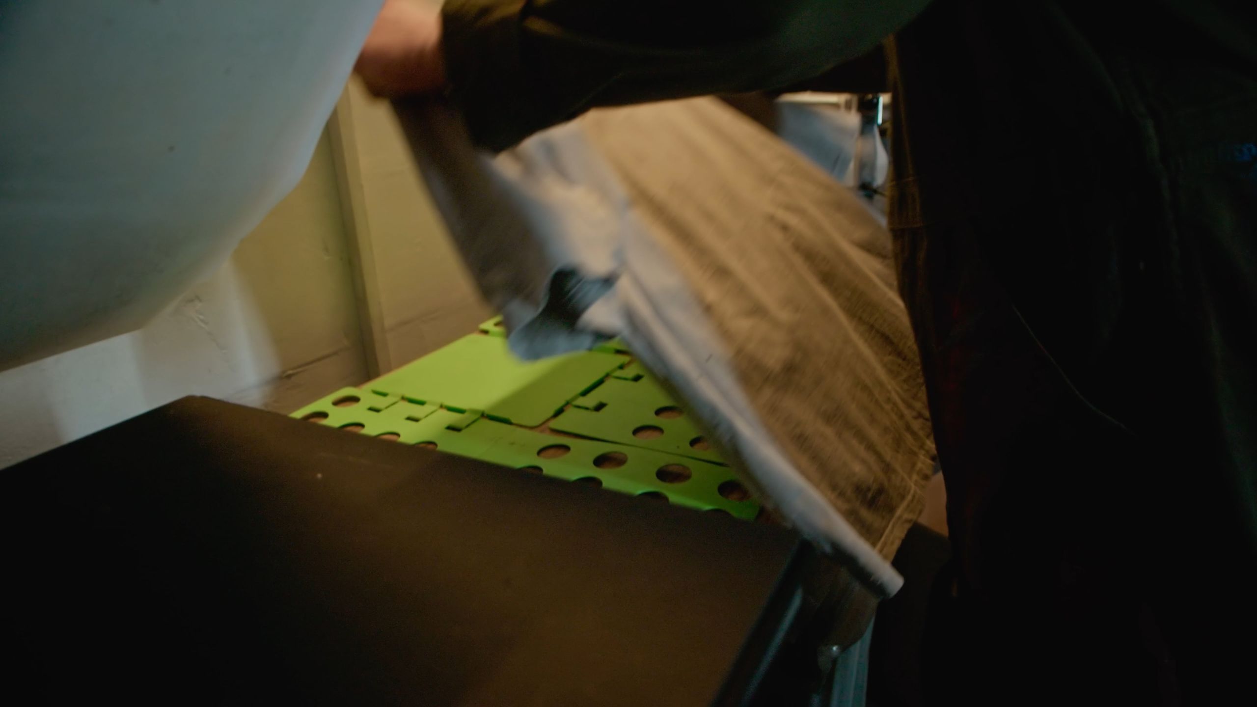 Hands folding a custom shirt on a merch folding board, from the Identity Start ecommerce banner