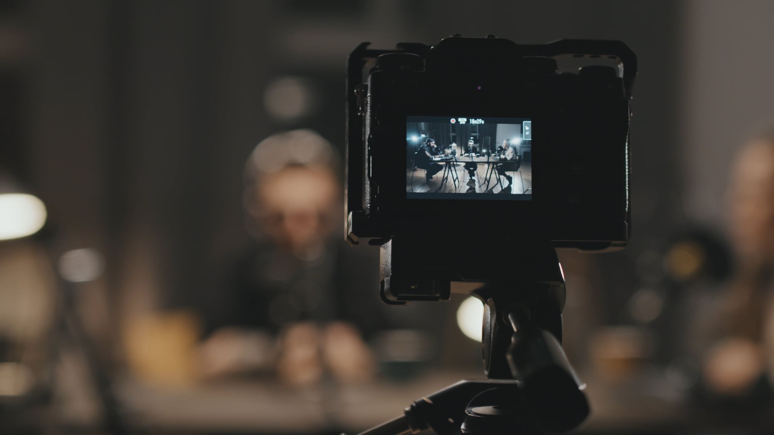 Camera monitor framing a podcast shoot in a moody studio, from the Identity Start videography banner