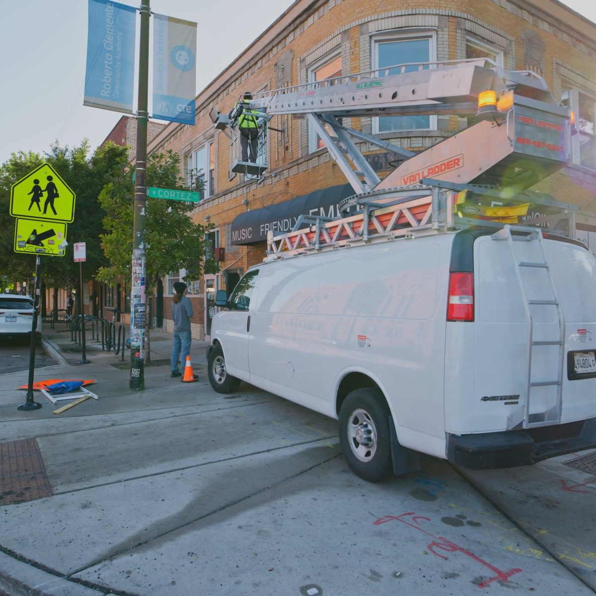 Sign technician on a ladder rack installing a storefront sign, filmed by Identity Start for a product and service video