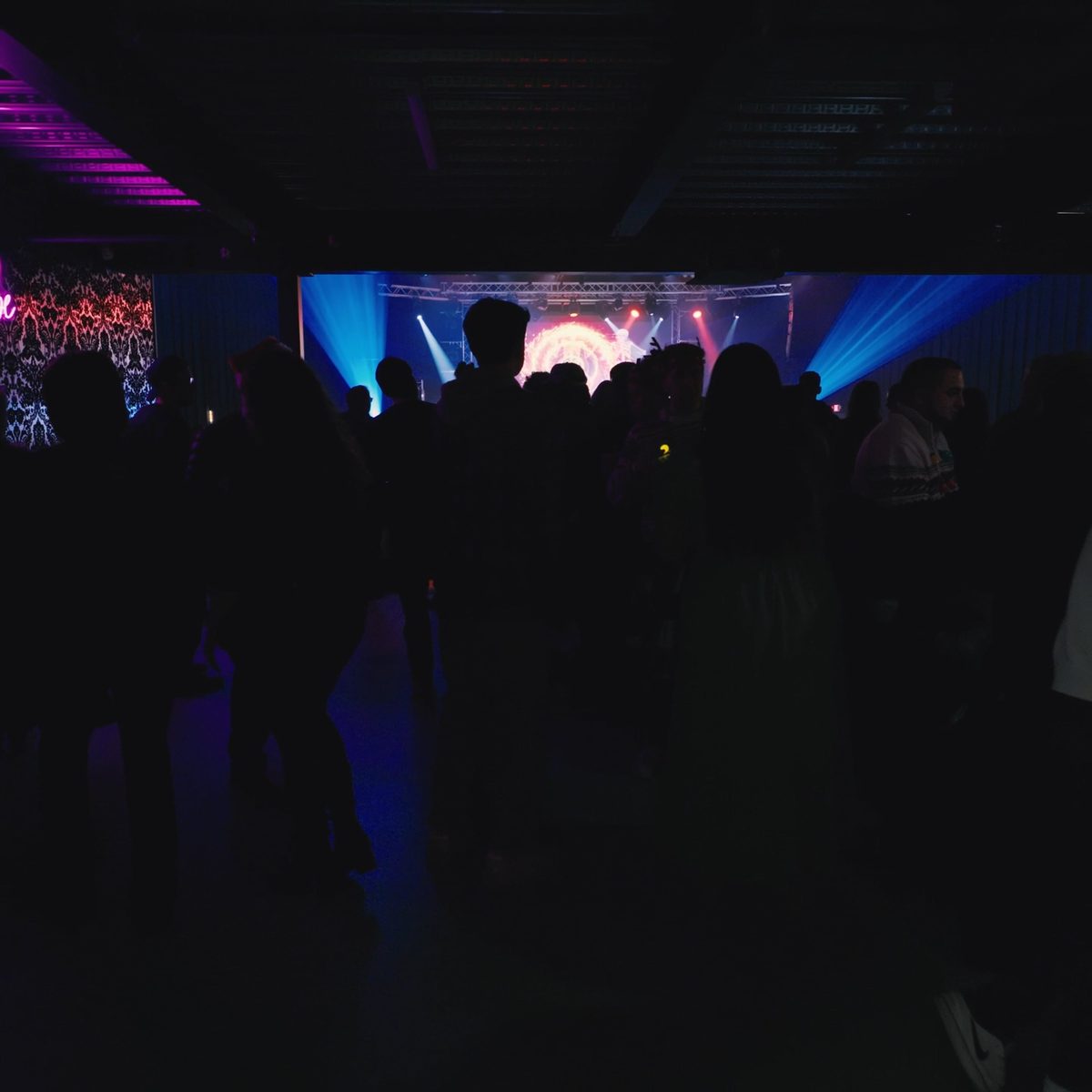 Crowd facing a lit stage at a live event, filmed by Identity Start for an event recap video