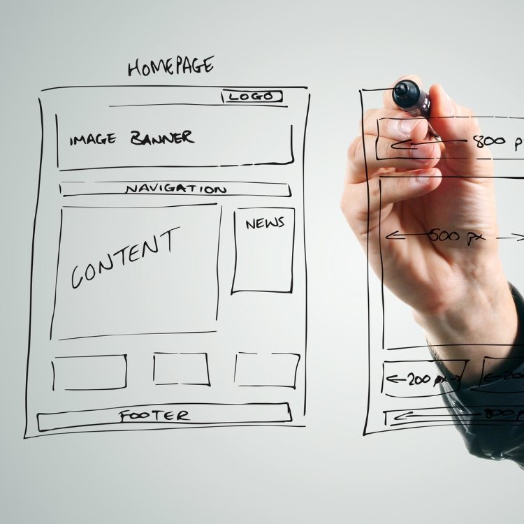 Hand sketching a homepage wireframe with banner, navigation, content and footer sections
