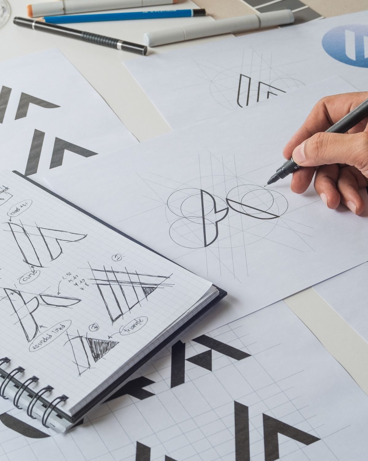Designer sketching logo concepts in a notebook