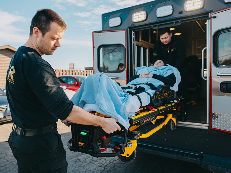 Northwest Rescue EMT loading a patient stretcher into an ambulance